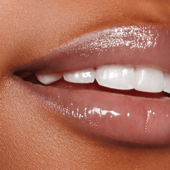 Zbliżenie na błyszczące, nawilżone usta o delikatnym odcieniu, efekt błyszczyka Kaja Heart Melter.