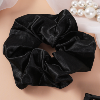 Czarna satynowa scrunchie LILU od Sister Young, gładka i błyszcząca, widok z góry na jasnym tle z perłami.