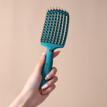 Widok z przodu: turkusowa wentylowana szczotka Ovia Sister Young z włosiem dzika i nylonem, trzymana w dłoni na beżowym tle.