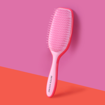 Różowo-koralowa szczotka do rozczesywania AYLA Sister Young, uchwycona pod kątem na różowo-pomarańczowym tle.