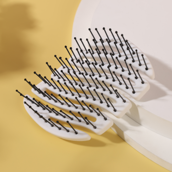 MILA Pocket Sister Young, biała mini szczotka z czarnymi nylonowymi szpilkami, pofalowany korpus, widok z góry.