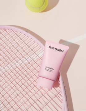 Różowy krem The Saem Eco Soul Perfect Cream na rakiecie tenisowej, z żółtą piłką, widok z góry.