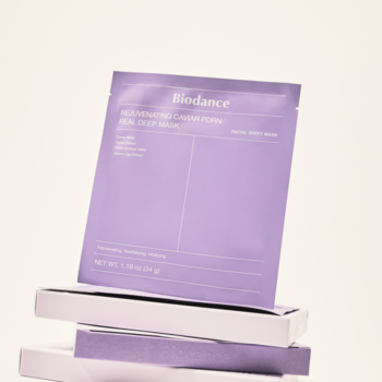 Fioletowa hydrożelowa maska Biodance Rejuvenating Collagen Real Deep z PDRN i kawiorem, na stosie pudełek, frontalnie.