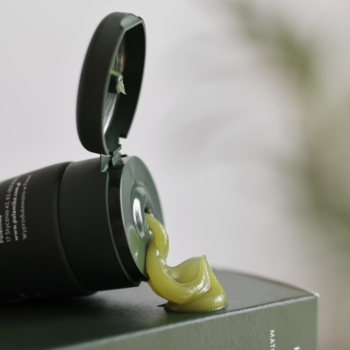 Polemika Matcha Cleanser, zielone masło oczyszczające z matchą, wyciśnięte z otwartej tubki. Bliski plan.