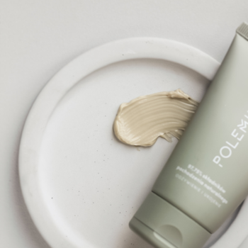 Polemika Matcha Care krem do rąk i paznokci w szarej tubce z napisem, obok beżowy swatch na białej tacy.