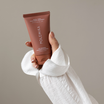 Polemika Matcha Purifier _Pro peeling-maska oczyszczająco-rozświetlająca w brązowo-różowej tubce, trzymana w dłoni.