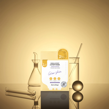 Maska Banobagi Glow Skin, żółte opakowanie z napisem, na tle laboratoryjnych kolb i złotych kulek.