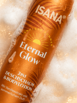 Pomarańczowa butelka Isana Eternal Glow 2w1, pianka z balsamem waniliowym w białej pianie, widok z góry.