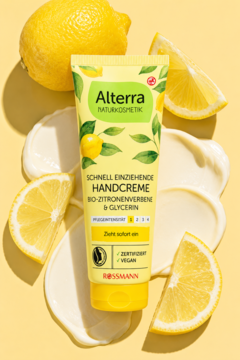 Alterra Naturkosmetik Bio-Zitronenverbene Handcreme w żółtej tubce na tle z kremem i cytrynami.