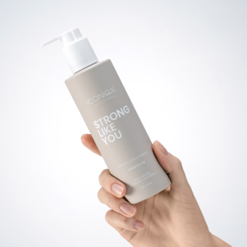 Szampon ICONIQUE Professional Strong Like You do włosów zniszczonych, beżowa butelka z pompką w dłoni.