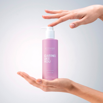 ICONIQUE Professional CARING LIKE YOU szampon nawilżający w fioletowej butelce z pompą, w dłoniach.