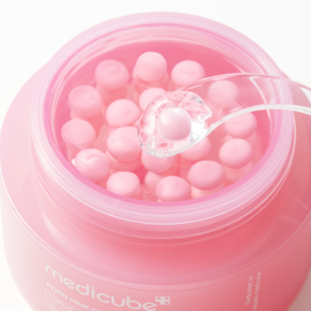 Otwarty różowy słoik Medicube PDRN Pink Collagen Capsule Cream. Różowe kapsułki w żelu, łyżeczka nabierająca krem.