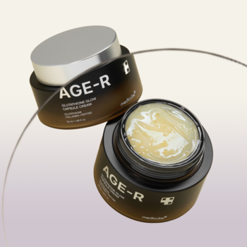 Dwa słoiki AGE-R Glutathione Glow Capsule Cream: jeden zamknięty, drugi otwarty, z widocznym żółtym kremem z kapsułkami.