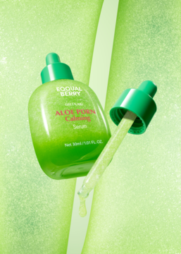 Kojące serum Eqqualberry Aloe PDRN Calming, zielona butelka z wyciągniętą pipetą, na jasnym, teksturowanym tle.