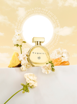 Złota, okrągła butelka perfum bugatti Essenza D’Oro, z białymi kwiatami i owocami, na tle żółtego blasku.