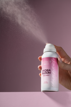 Różowo-biała mgiełka do twarzy AFFECT HYDRA BLOOM w akcji, trzymana w dłoni, rozpyla nawilżającą mgiełkę.