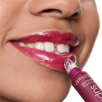 Zbliżenie na usta kobiety nakładającej lśniący balsam Essence the super peptide 08 Cherrylicious w tubce.