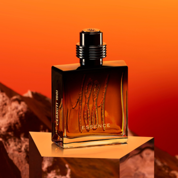 Męskie perfumy Cerruti 1881 Essence, elegancki ciemny flakon ze złotym napisem, na złotej platformie, pomarańczowe tło.