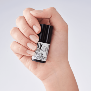 Dłoń z beżowymi paznokciami trzyma czarny top coat UV Perfect Ending 01 z białym napisem.