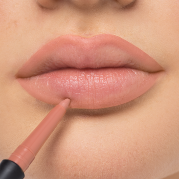 ARTDECO Mineral Lip Styler, zbliżenie na usta. Aplikacja beżowej kredki do ust, precyzyjne konturowanie.