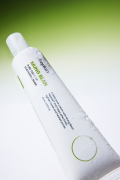 Biała tuba kremu Beplain Mung Bean Pore Tight-Up Soothing Cream z kroplami wody, pod kątem, na zielono-białym tle.