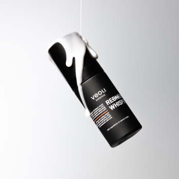 Czarna butelka serum Veoli Botanicals REDNESS WHISPERER z białym kremem spływającym, widok pod kątem.