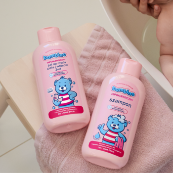 Dwie różowe butelki hipoalergicznego żelu 2w1 i szamponu Bambino dla niemowląt, na różowym ręczniku.