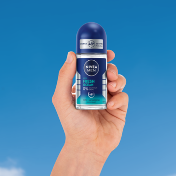 Niebieski NIVEA MEN Fresh Ocean roll-on 48h, 0% aluminium, w dłoni na tle błękitnego nieba.