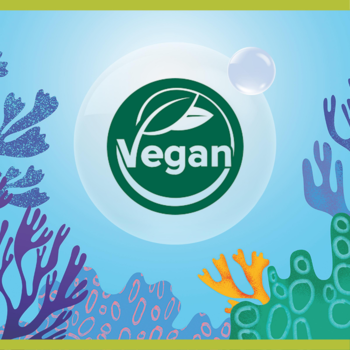 Logo Vegan Palmolive Aquarium z zielonym liściem, umieszczone na błyszczącym kręgu z koralowym tłem.