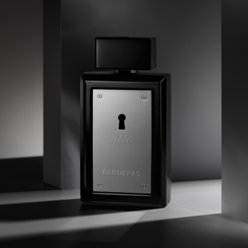 Antonio Banderas The Secret - męskie perfumy w czarnym flakonie ze srebrną płytką i dziurką od klucza, widok z przodu.