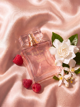 Perfumy follow the beauty w butelce na różowym atłasie. Obok świeże maliny i biała gardenia. Nuty: malina, karmel, gardenia.