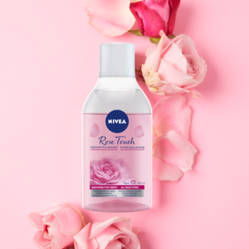 Biała butelka NIVEA Rose Touch Micelarnego płynu dwufazowego, z etykietą róży na różowym tle z płatkami.
