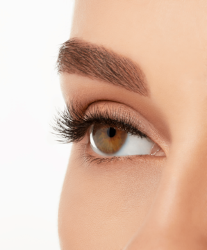 Kobiecie brązowe oko z rzęsami Ardell Naked, podkreślające subtelną długość i objętość, widok z boku.