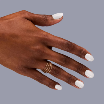 Semilac Fiber Base, mleczna baza hybrydowa. Dłoń z paznokciami w mlecznym odcieniu, wzmocnionymi włóknami nylonowymi.