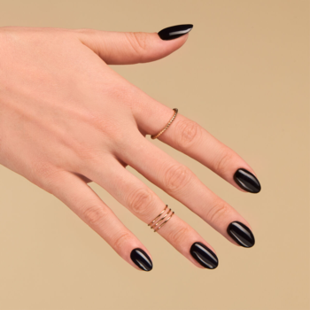 Dłoń z manicurem Semilac 031 Black Diamond: głęboka czerń, błyszczące paznokcie, dwa złote pierścionki, na beżowym tle.