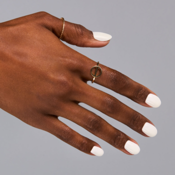 Semilac 001 Strong White na dłoni: śnieżnobiały, kryjący lakier hybrydowy, widoczny złoty pierścionek.