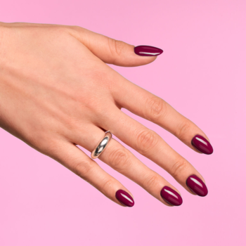 Widok z góry: dłoń z paznokciami pomalowanymi lakierem Semilac 028 Classic Wine, nasycona czerwień, na różowym tle.