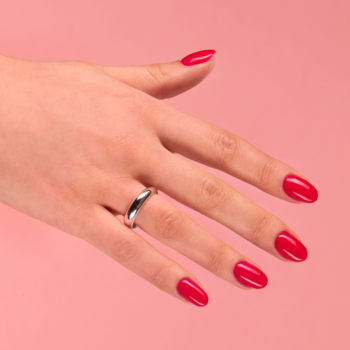 Lakier hybrydowy Semilac 103 Elegant Raspberry na paznokciach, neonowa malinowa czerwień, dłoń na różowym tle.