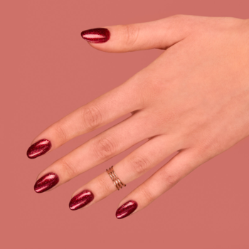 Dłoń z paznokciami pomalowanymi Semilac 181 Spicy Salsa, karminowy lakier hybrydowy z metalicznym, perłowym wykończeniem.