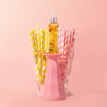 SO...? mgiełka do ciała Vanilla Milkshake, butelka z żółtym płynem, między szklankami ze słomkami i różowym kubkiem.