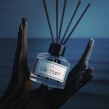 Pachnące patyczki Ellie Pure w szklanej butelce, na ciemnym drewnie, tle niebieskiego morza nocą.