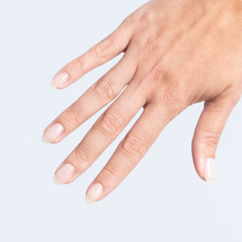 Elegancka dłoń z naturalnymi, owalnymi paznokciami o idealnym połysku, ukazująca efekt Bazo/Top 2w1.