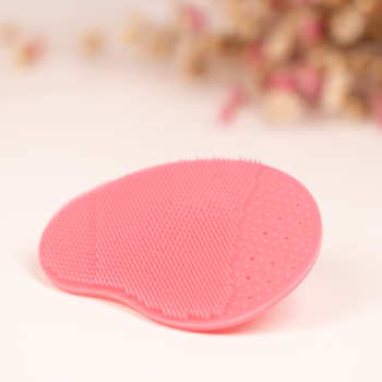 Różowy silikonowy płatek do mycia i masażu twarzy, widok z góry na teksturę z wypustkami.