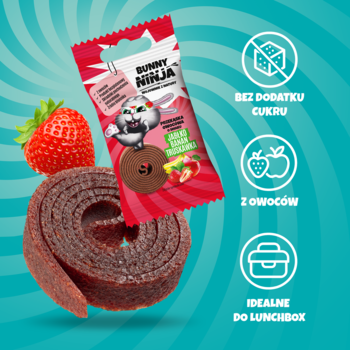 Przekąska owocowa Bunny Ninja (jabłko, banan, truskawka) – suszona, zwinięta rolka obok truskawki, na tle turkusu.