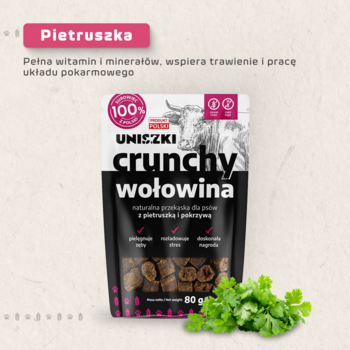 Przysmaki Uniszki Crunchy Wołowina dla psa w czarnej paczce z różowymi akcentami i świeża pietruszka.