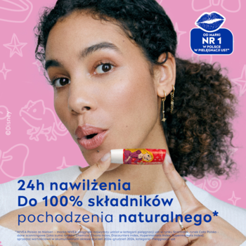 Kobieta z kręconymi włosami trzyma pomadkę NIVEA Wild Cranberry Roszpunka. Czerwone opakowanie, napis: 24h nawilżenia.