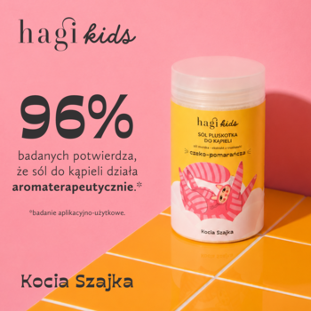 Hagi Kids sól do kąpieli Kocia Szajka, czekoladowo-pomarańczowa, w żółtym pojemniku, na tle pomarańczowo-różowych płytek.