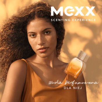 Kobieta z burzą loków i MEXX Inspired Glow, promienna woda perfumowana dla niej, butelka na słonecznym tle.