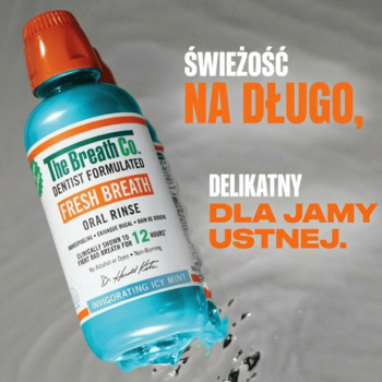 Płyn The Breath Co. Fresh Breath Icy Mint, turkusowa butelka z pomarańczową nakrętką, wylewa się w wodzie, napisy reklamowe w tle.