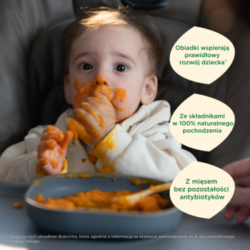 Maluch je obiadek z kluseczkami, warzywami i indykiem, brudząc się. 100% naturalne składniki, bez antybiotyków.